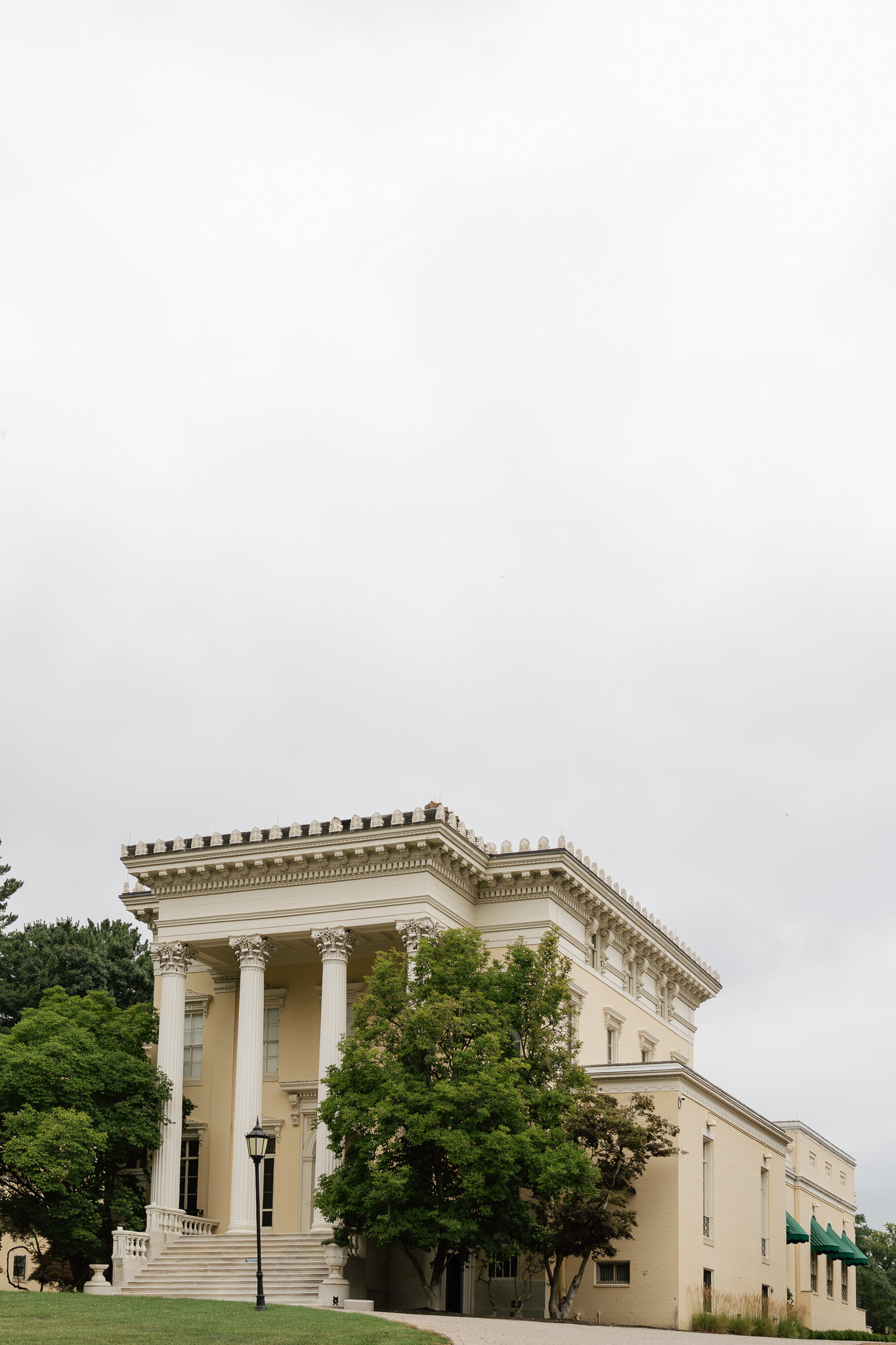 historic old white house surrounded by trees by East Coast Wedding Photographer