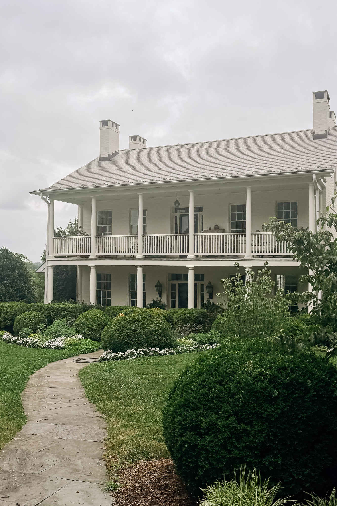 old white house surrounded by a garden showing best wedding venues in Maryland