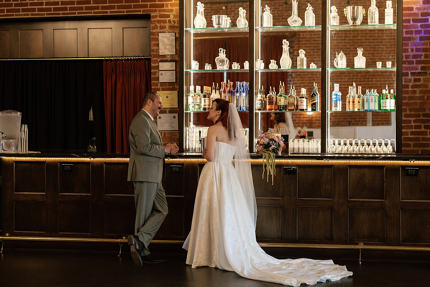 newlyweds share a drink at the indoor bar by Sharp Impressions Photography