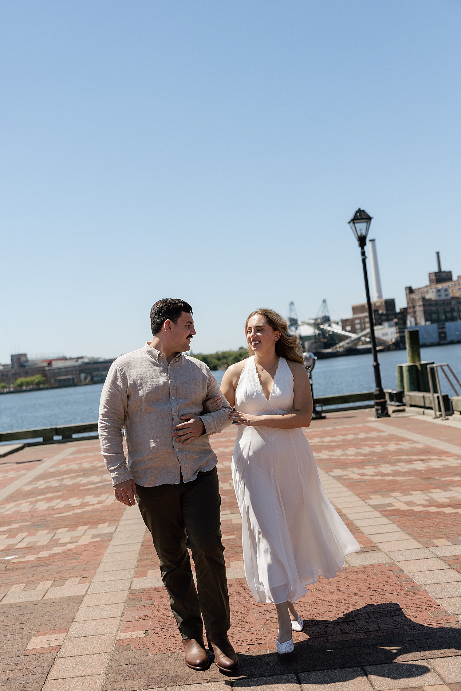 man and woman walk arm in arm on pier by Maryland wedding photographer