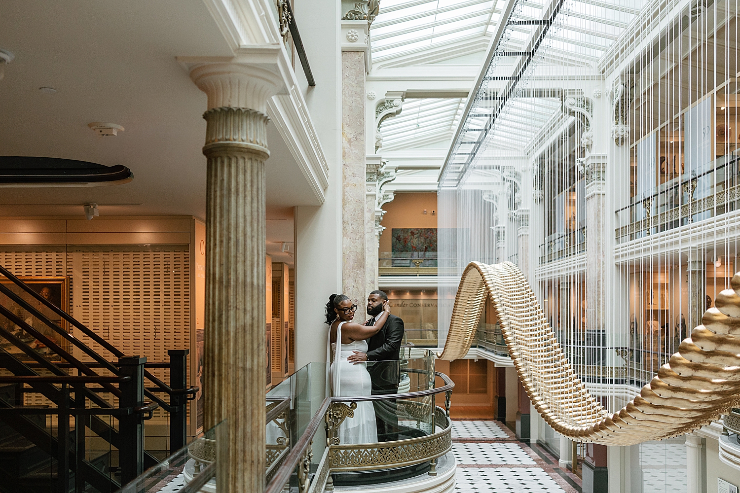 man embraces woman on balcony inside the National Portrait Gallery