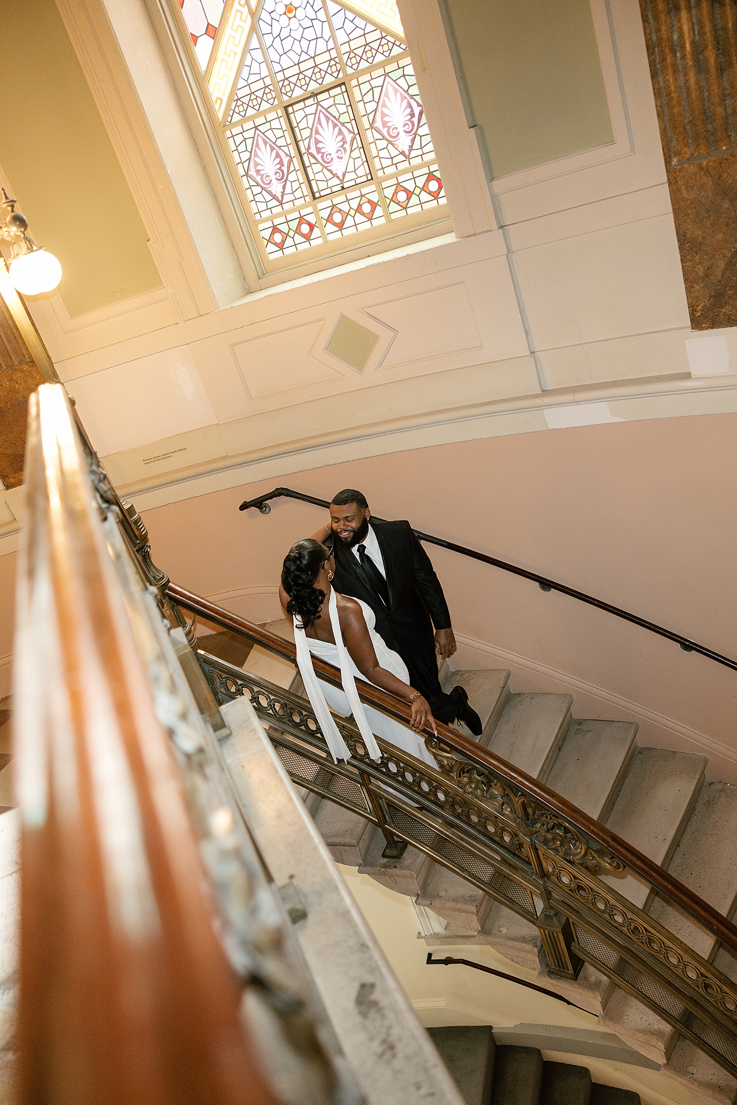 couple stand on sweeping staircase at National Portrait Gallery
