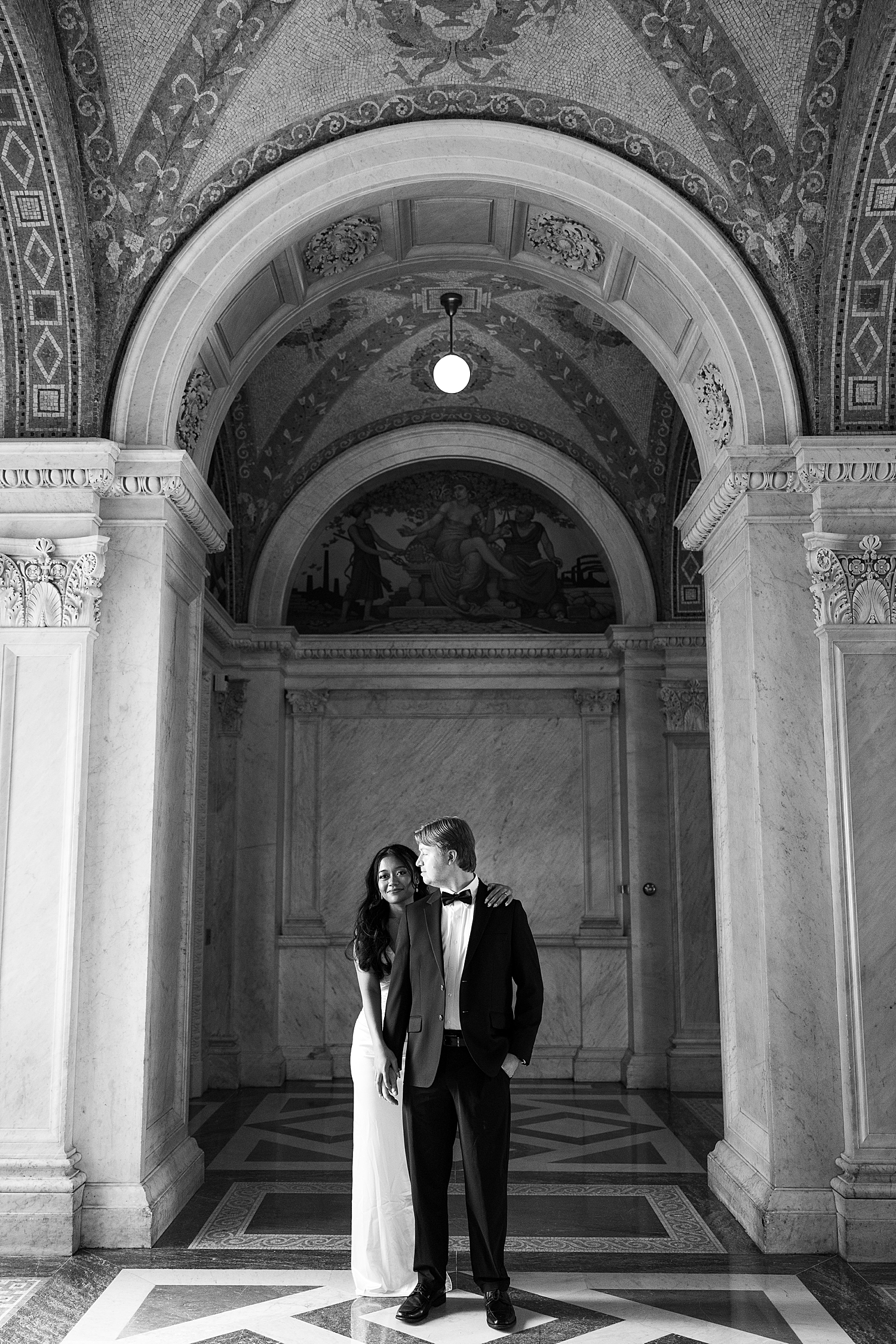 bride and groom to be snuggle close in historic building by Maryland wedding photographer