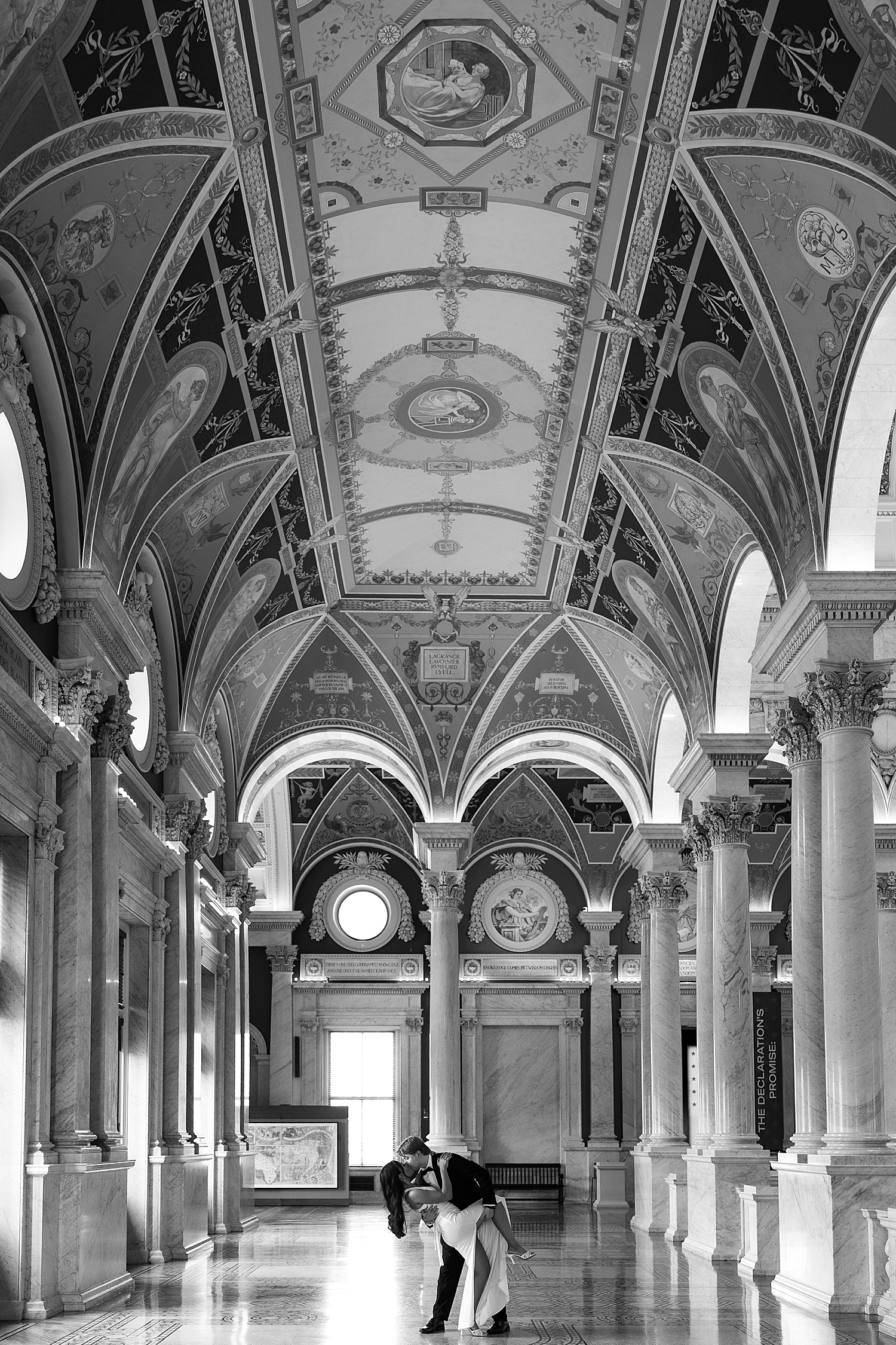 man dips wife-to-be for a kiss in big historic hallway by Sharp Impressions Photo