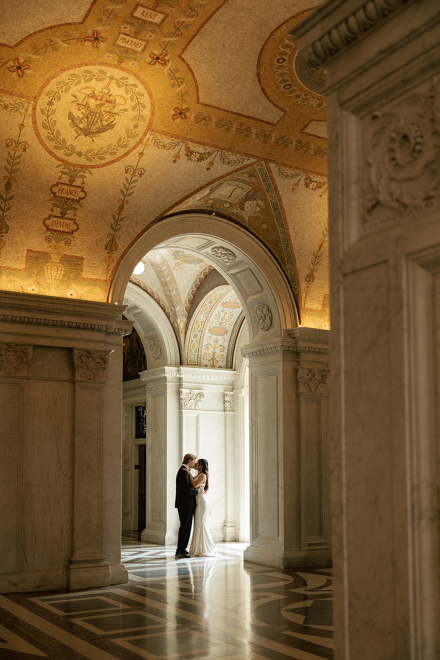 couple share a private kiss in hallway full of natural light by Sharp Impressions Photo