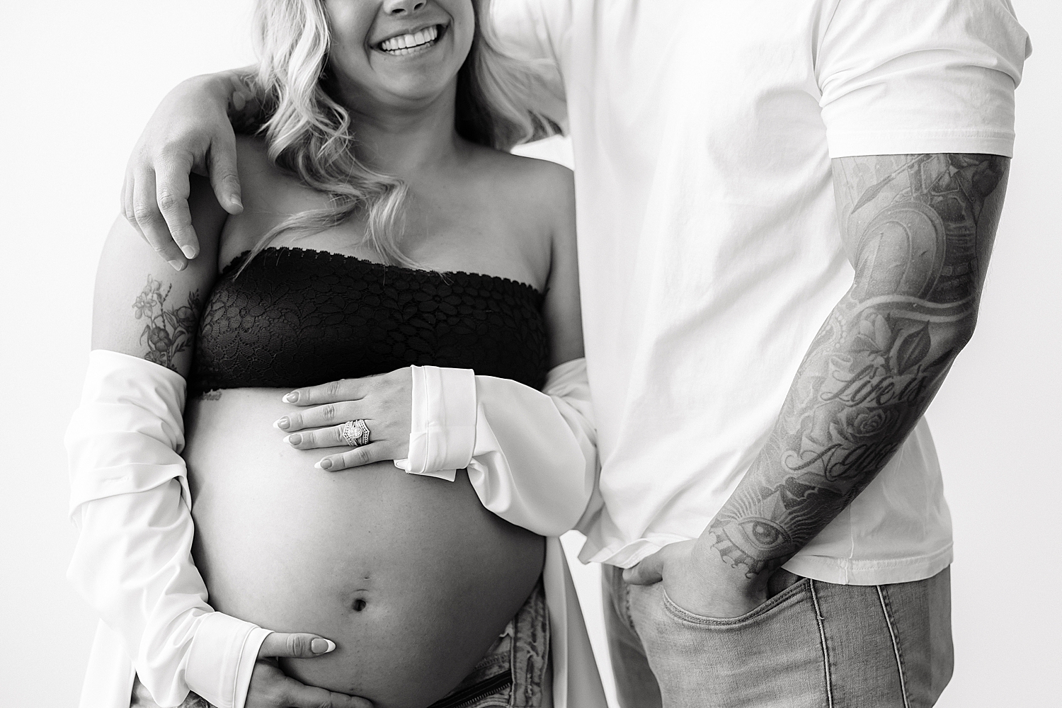 woman giggles while holding her bump by Maryland family photographer
