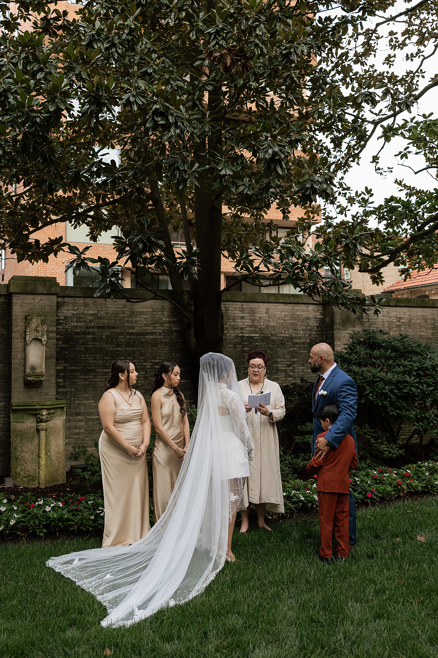 woman with veil and man in suit on lawn for private ceremony by Maryland wedding photographer