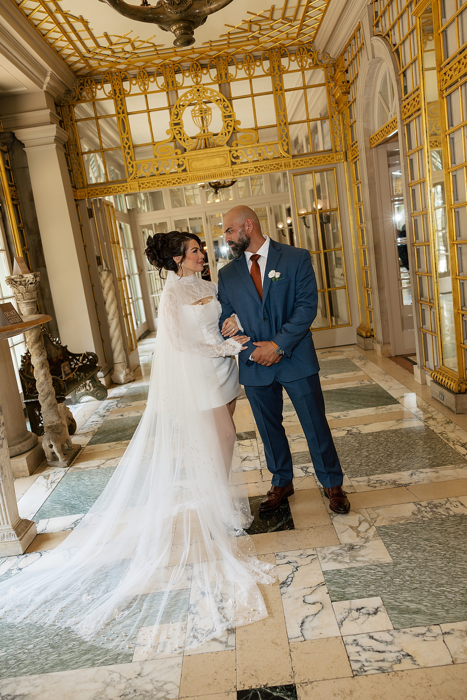 newlyweds stand side by side in atrium by Maryland wedding photographer