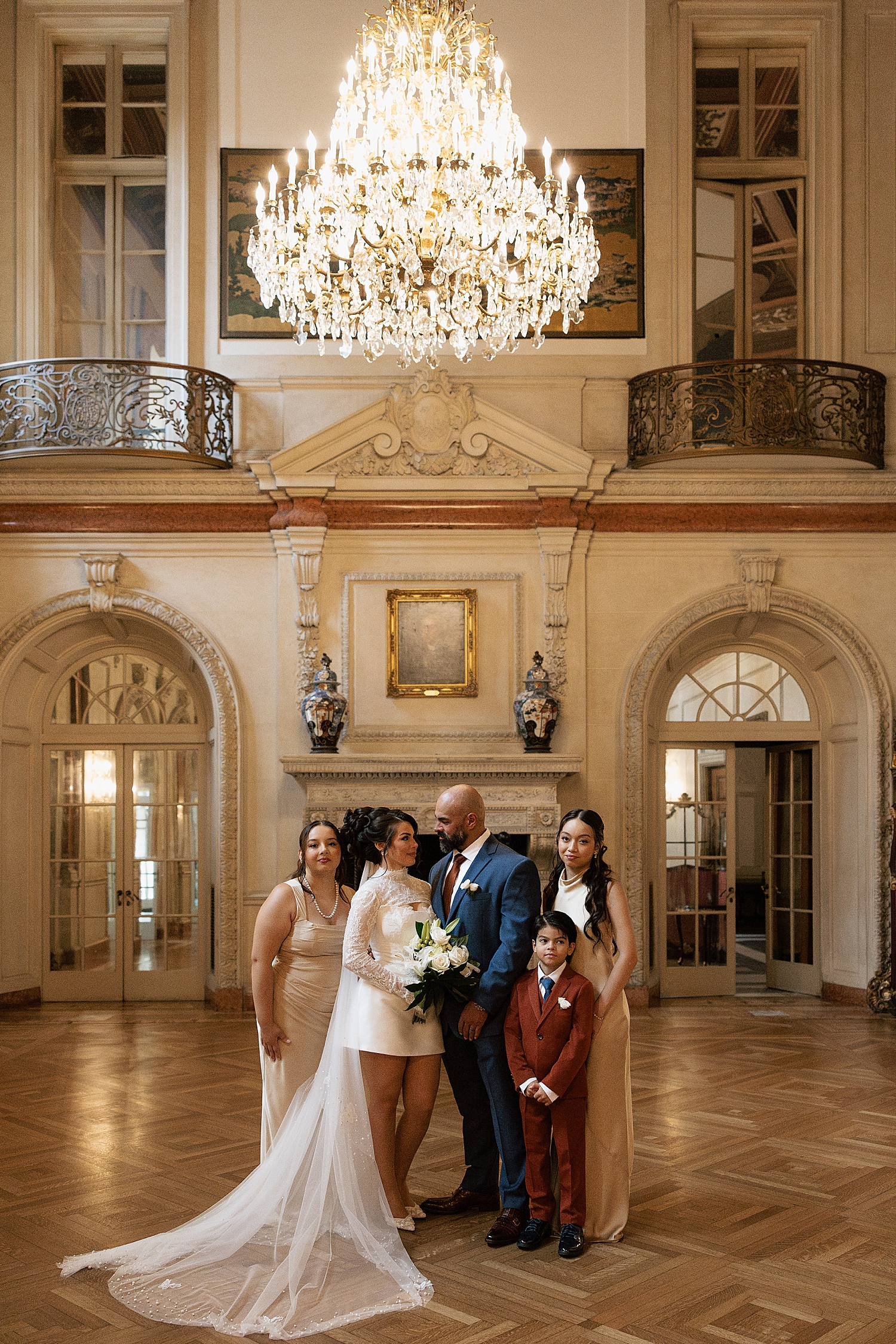 couple surrounded by family in grand foyer for Anderson House Elopement