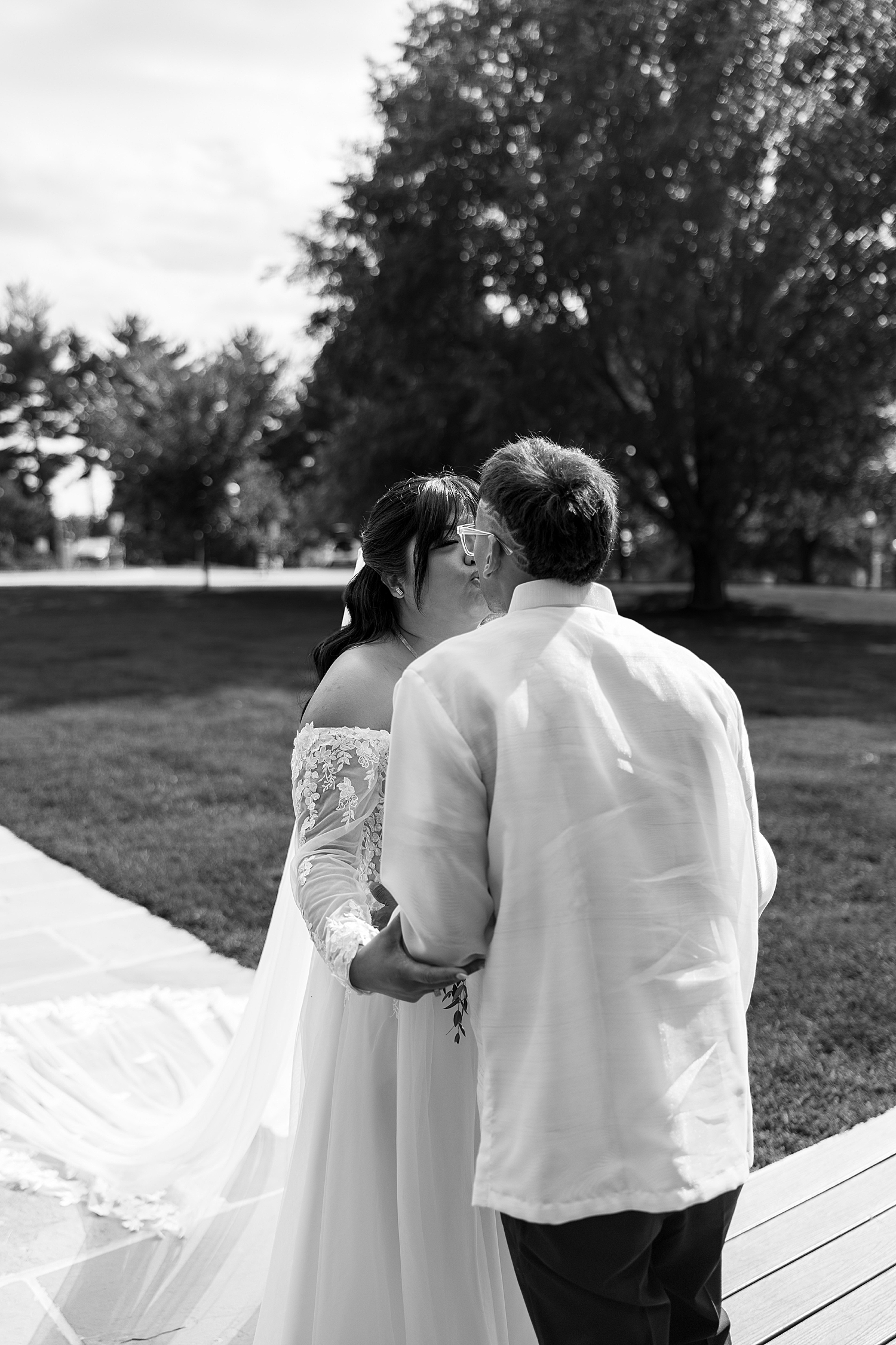 couple share a kiss after their first look in garden by Maryland wedding photographer