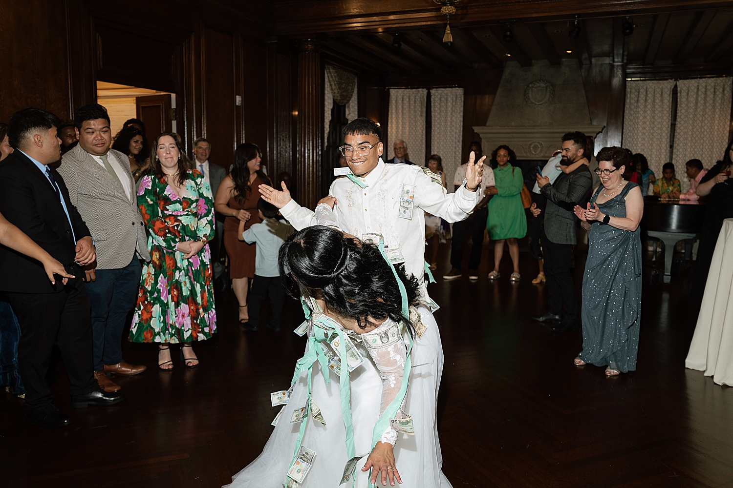 newlyweds dance with money attached to them on dance floor by Sharp Impressions Photography