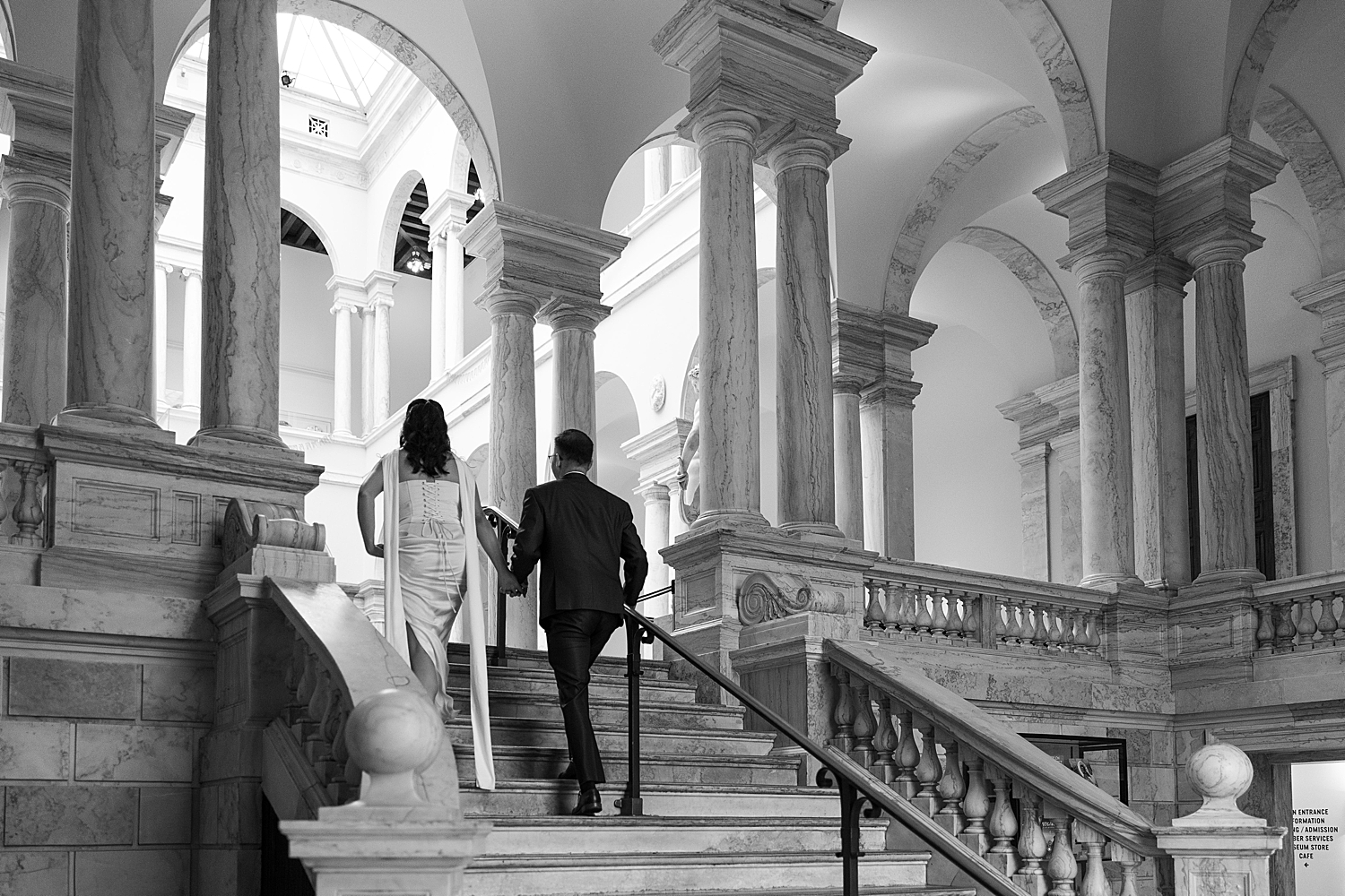 man and woman climb stairs at art gallery showing Engagement Session Locations in Baltimore