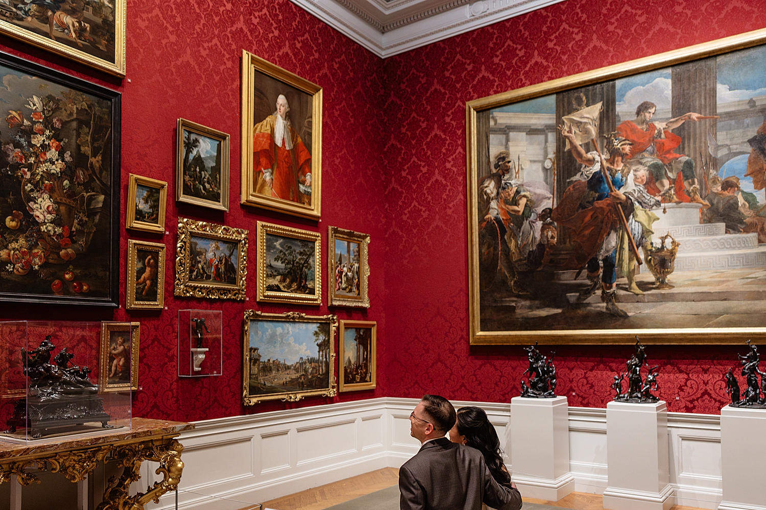 man and woman sit on bench to look at art by Maryland wedding photographer