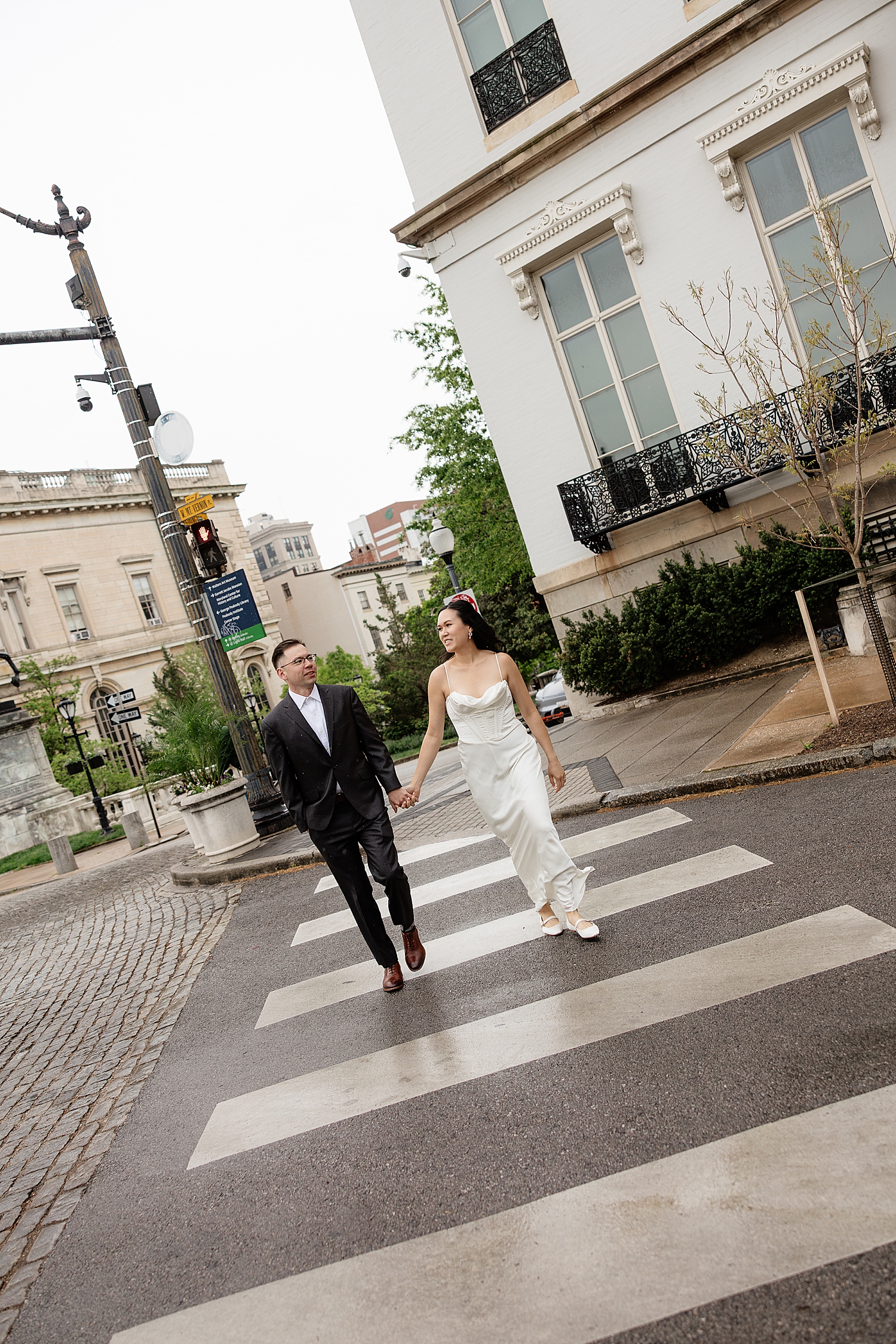 man and woman cross street showing Engagement Session Locations in Baltimore