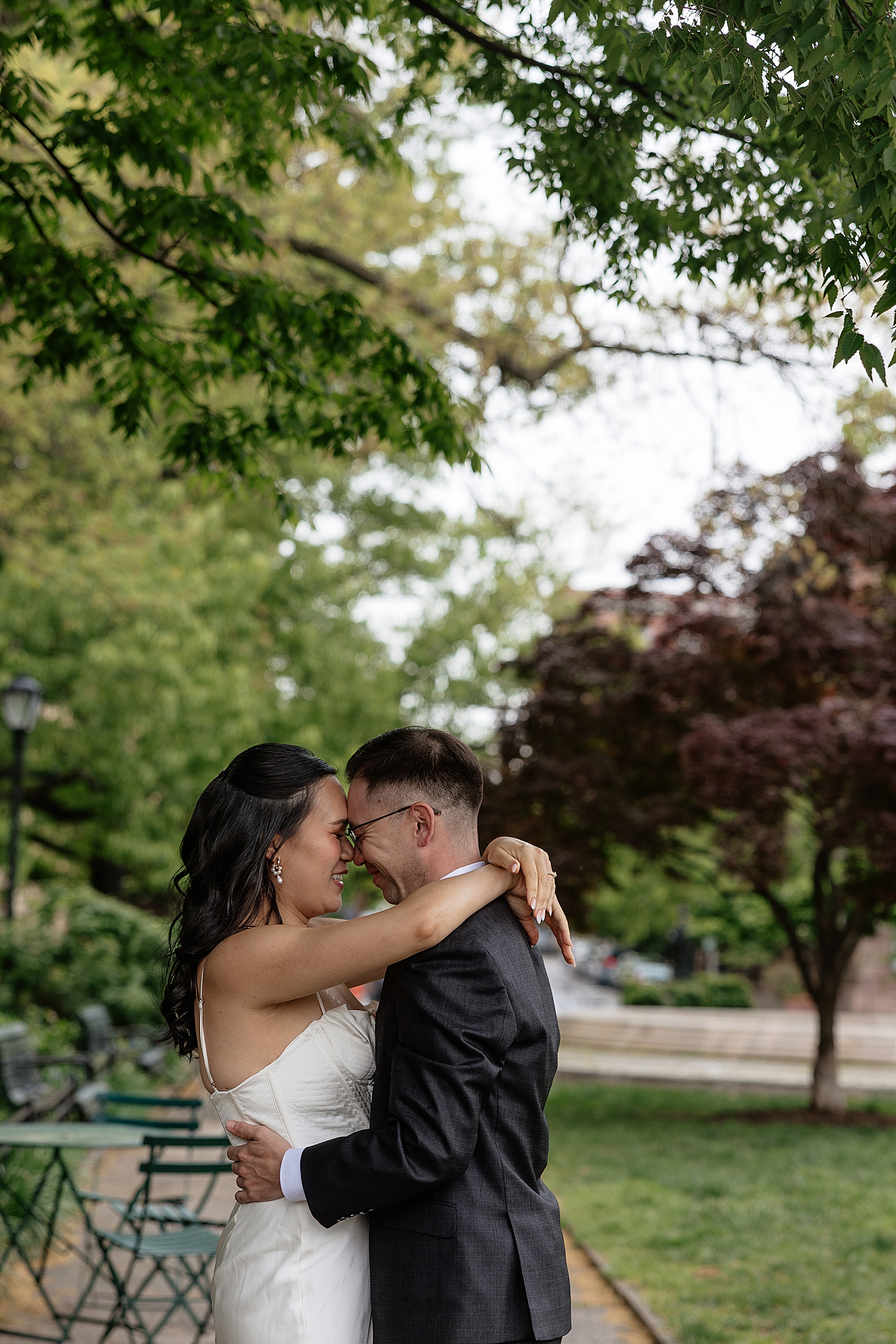 woman in white dress embraces her man in park by Maryland wedding photographer